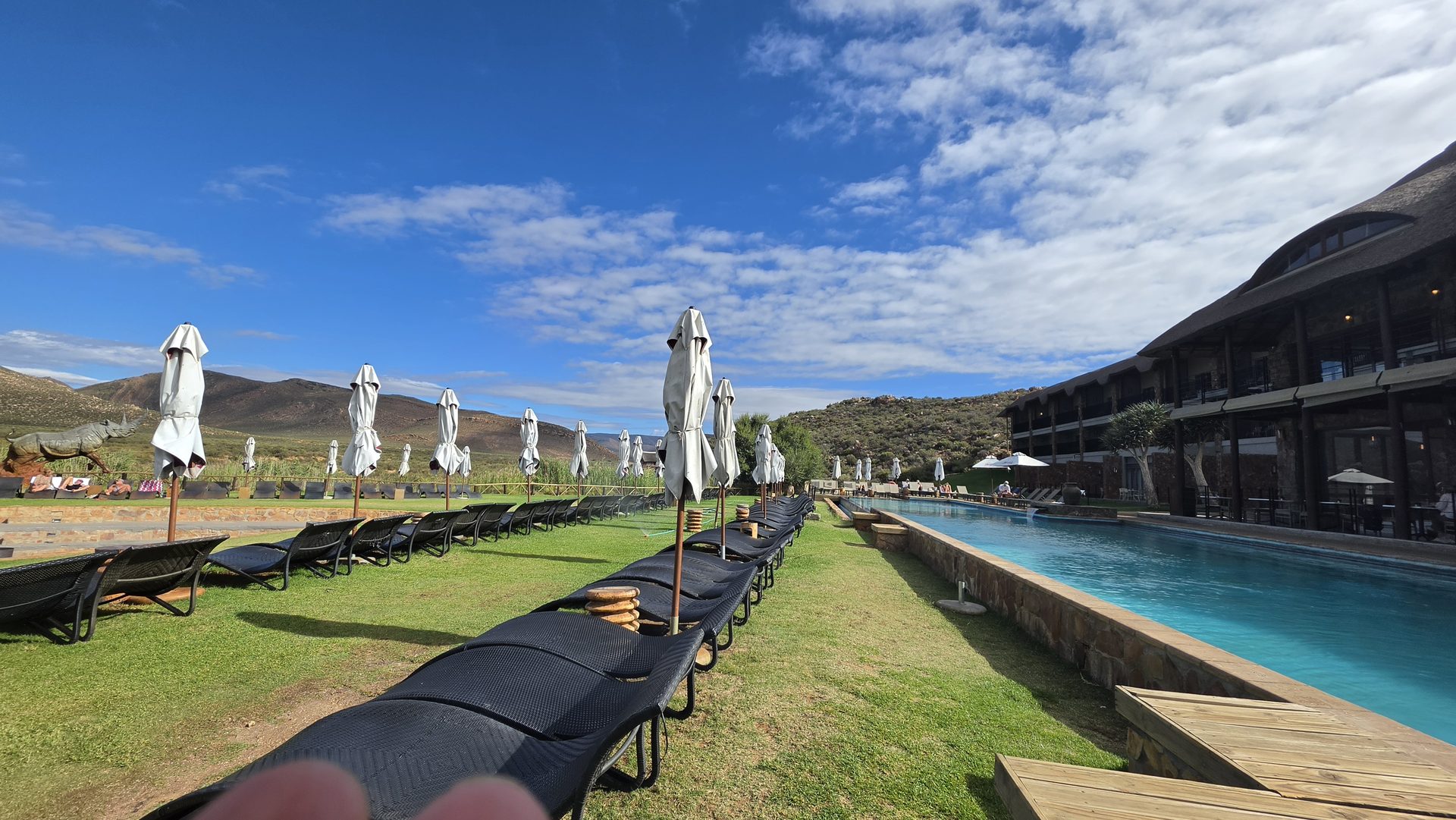 Pool and lodge loungers at Aquila with Karoo mountains behind