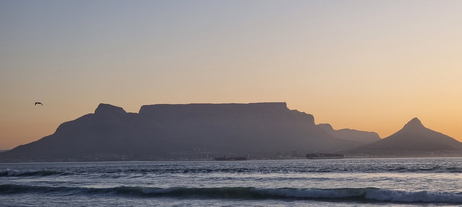 Table Mountain, Devil's Peak and Lion's Head silhouetted across Table Bay from Bloubergstrand