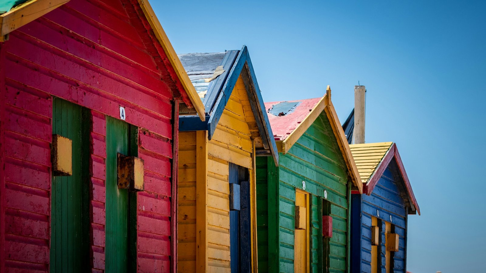 The row of red, yellow, green and blue Victorian bathing boxes on Muizenberg beach, Cape Town