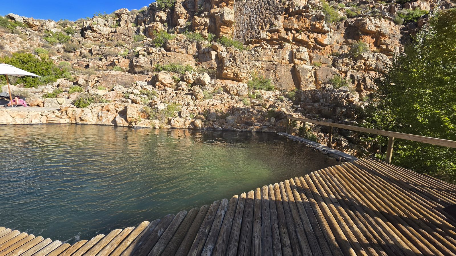 Rock pool with wooden deck beneath cliffs in the Klein Karoo